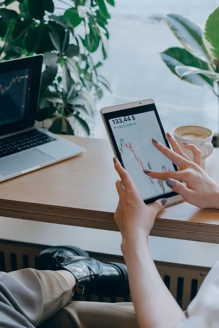 Tre donne con hijab lavorano insieme su strategie di pubblicità digitale attorno a un tavolo con laptop.
